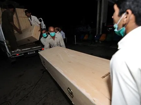  Membros de equipe de resgate ajudam a transportar caixões que vão ser usados para depositar os restos mortais das 152 pessoas mortas no acidente