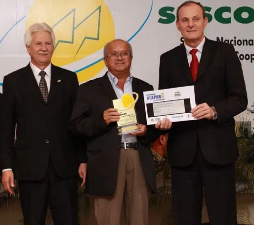  O jornalista Edison Costa recebe o prêmio de Manfred Dasenbrock, presidente do sicredi, ao lado de João Paulo Koslovski