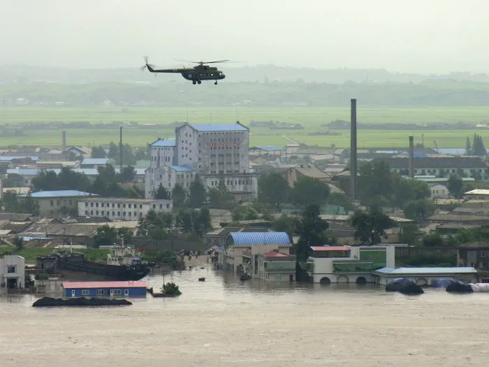  Helicóptero de resgate sobrevoa cidade inundada na fronteira entre China e Coreia do Norte, neste sábado (21)