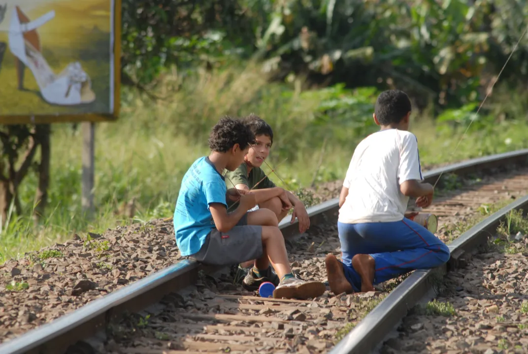  Crianças brincam de soltar pipa na linha férrea 
