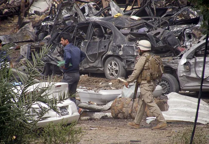 Militar caminha perto de local da explosão de um carro-bomba no bairro residencial de Al Mansur 