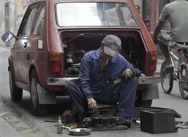  Homem conserta carro em rua de Havana nesta quinta-feira (23)