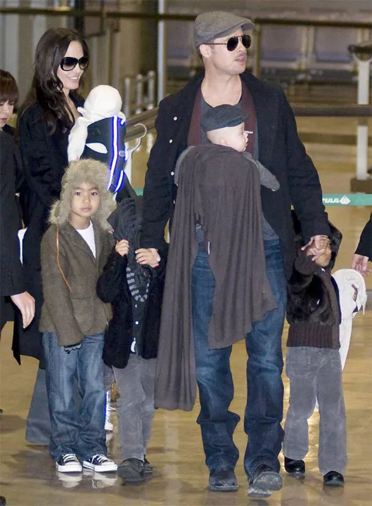 Brad Pitt e Angelina Jolie com os filhos, Maddox (à esq.), Pax (ao lado), Vivienne (nos braços de Jolie), Zahara (à dir.), e Knox (nos braços de Pitt) Pitt e Jolie com os filhos, Maddox (esq.), Pax (ao lado), Vivienne (nos braços de Jolie), Zahara (à dir.), e Knox (nos braços de Pitt)