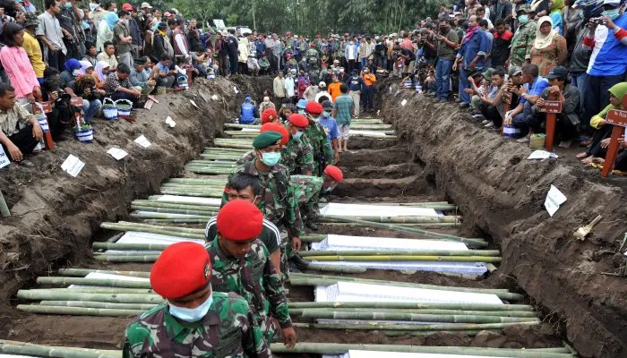  População observa enterro de vítimas de vulcão na cidade de Sidorejo, perto do monte Merapi, na Indonésia, nesta quinta