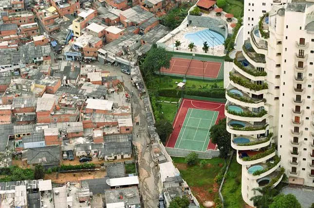 Muro separa favela de condomínio de luxo em São Paulo