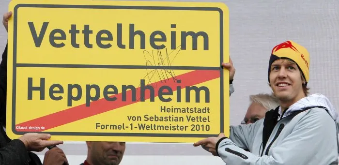  Vettel em visita à sua cidade natal. Na foto, ele recebe uma homenagem em que nome da cidade seria Vettelheim