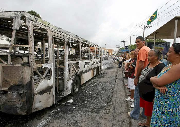  Moradores observam ônibus incendiado por criminosos