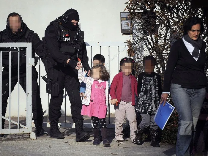  Membros do Grupo de Intervenção da Polícia Nacional conduzem as crianças e a professora para fora da escola infantil