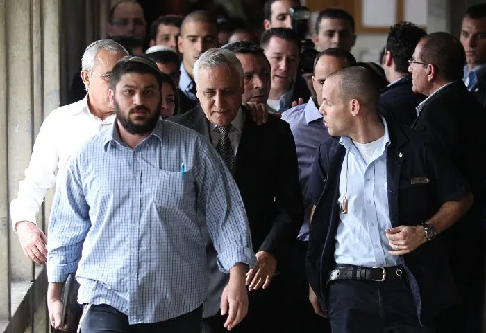  Moshe Kasav (de gravata) deixa tribunal após a leitura do veredicto em seu julgamento por estupro