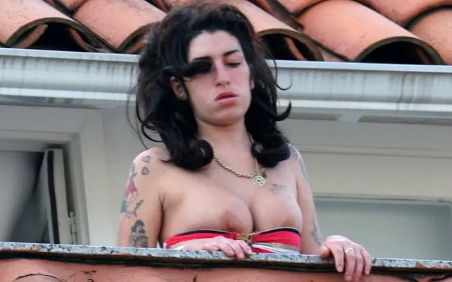  Amy Winehouse deixa os seios à mostra