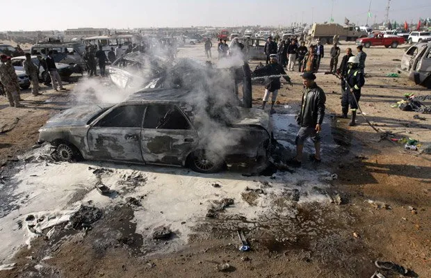  Bombeiros apagam fogo em um dos carros-bomba usados nos ataques desta quinta-feira (20) na cidade iraquiana de Kerbala