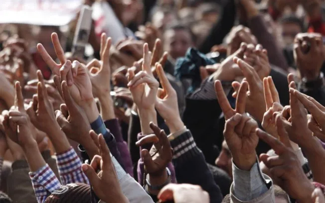  Manifestantes antigoverno fazem sinal da vitória na praça Tahrir, do Cairo