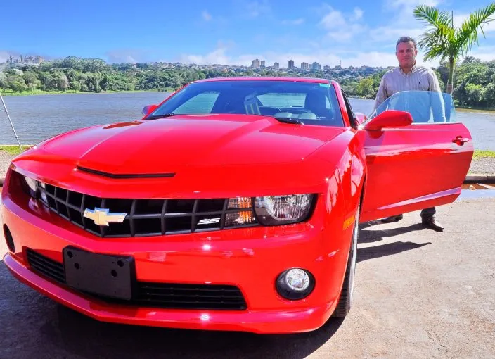   Alessandro Santos, gerente de vendas da Apucarana Auto Peças, ao lado de um dos cinco Camaros vendidos na cidade pela “bagatela” de R$ 185 mil cada