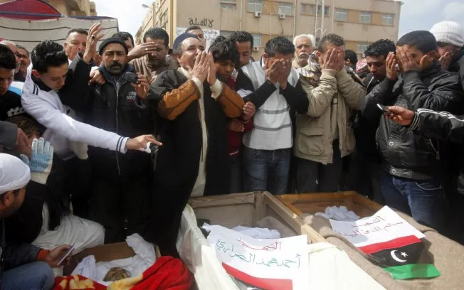  Manifestantes antigoverno rezam em frente de caixões de vítimas de confrontos recentes em Benghazi, leste da Líbia