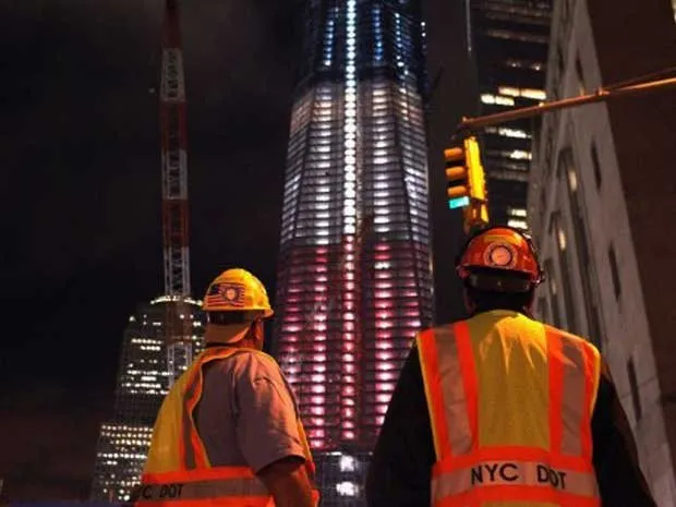 Trabalhadores observam as cores da bandeira dos Estados Unidos projetadas na Freedom Tower, que fica na região onde estavam as Torres Gêmeas, em Nova York. O país se prepara para o 10 º aniversário da tragédia provocada pelos ataques terroristas ao World