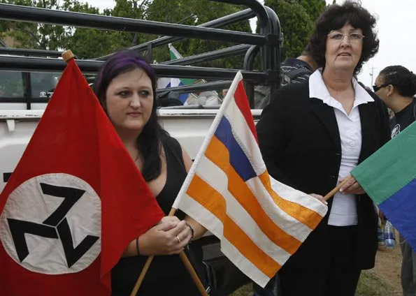  Ativistas pró-supremacia branca mostram bandeiras durante ato em frente de igreja em Ventersdorp
