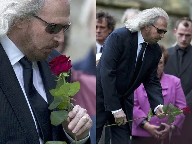  Barry Gibb, único integrante vivo dos Bee Gees, beija uma flor antes de jogá-la no caixão com o corpo de seu irmão Robin