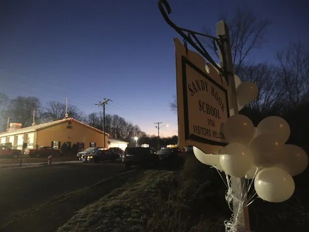  Balões brancos decoram placa que indica direção da escola Sandy Hook, na manhã deste sábado (Foto: AP) 