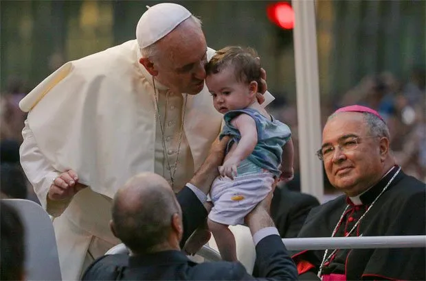 Crianças são levadas por membros da comitiva ao papa e depois são devolvidas para o colo dos pais
