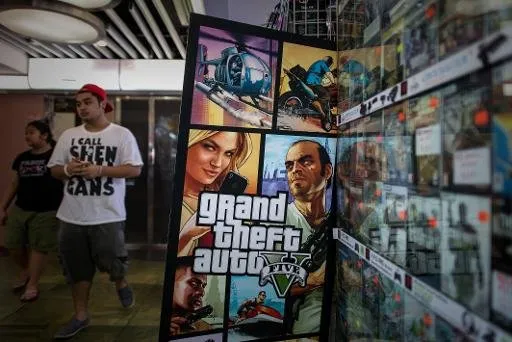 Um homem perto de um painel do jogo "Grand Theft Auto V", em Hong Kong (AFP Photo, PHILIPPE LOPEZ)