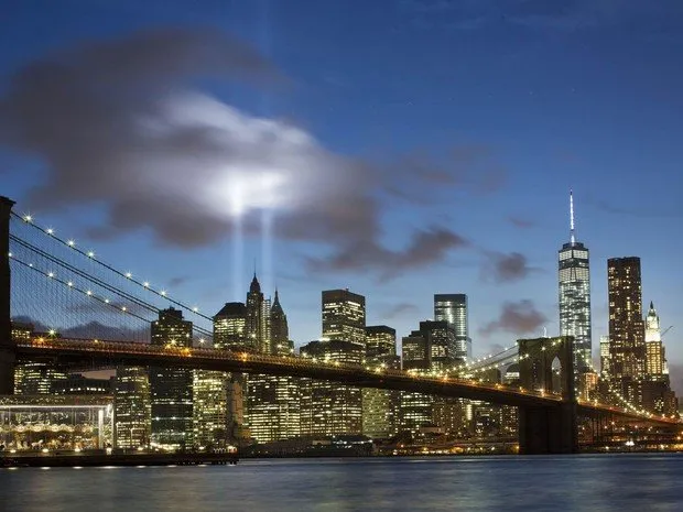 Dois enormes fachos do Tributo de Luz iluminam o céu de Nova York por trás da Ponte do Brooklyn -  (Foto: Mark Lennihan/AP)