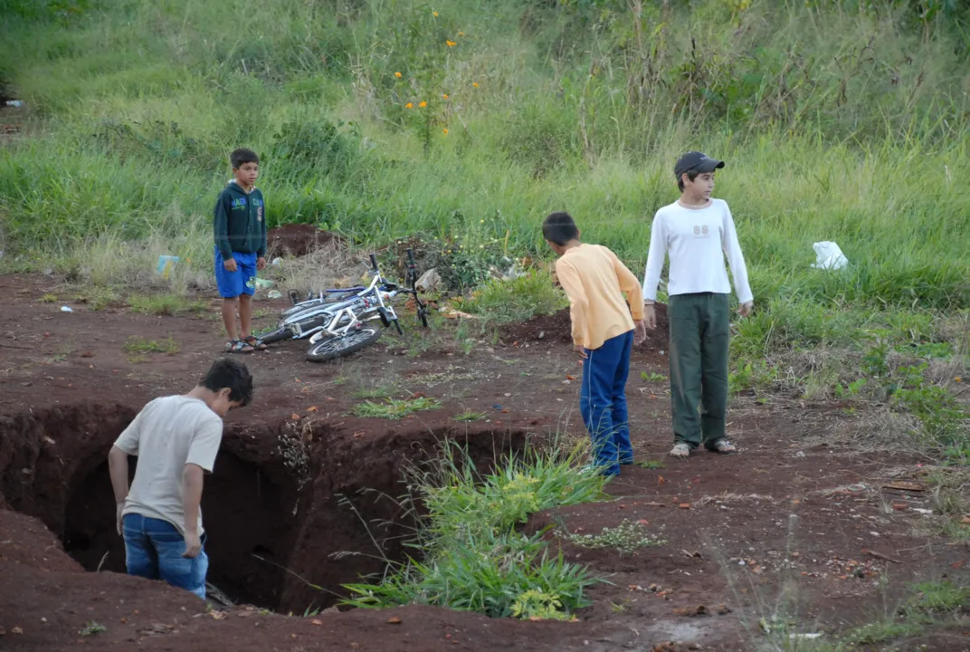 Crianças brincam ao lado do buraco de 2 metros de profundidade