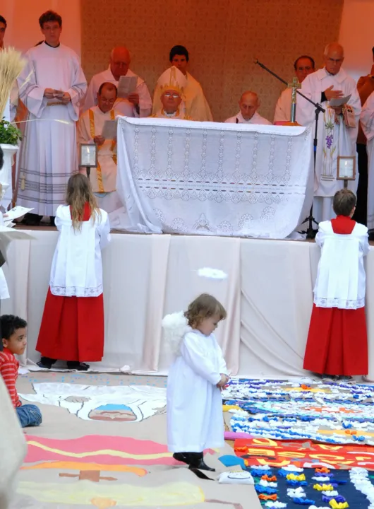  Criança vestida de anjo observa tapetes de Corpus Christi