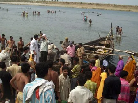  Moradores locais observam trabalhos de resgate após naufrágio na Índia; barco com cerca de 60 pessoas virou no meio de rio Ganges, no norte do país