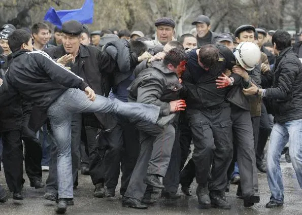  Manifestante chuta policial durante confrontos em Bishkek, no Quirguistão, nesta quarta (7) 