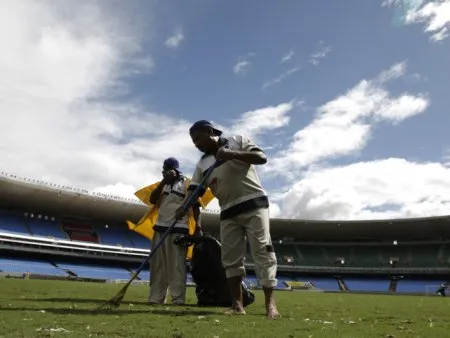  Funcionários varrem gramado do Maracanã; jogo seria na noite desta quarta