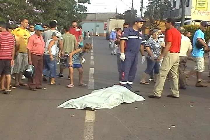 Garoto observa corpo coberto de homem morto em acidente na cidade de Arapongas: cena tétrica