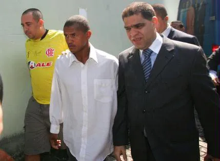  Santos (no centro) chega à delegacia ao lado do Partor Marcors Pereira da Silva