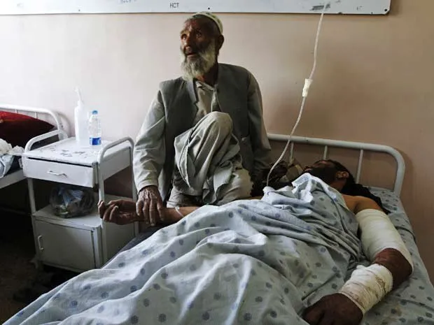  Pai conforta filho ferido em ataque a casamento no Afeganistão