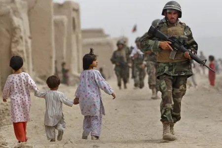  Soldados afegãos e canadenses passam por crianças durante patrulha no vilarejo de Bazaar e Panjwaii, no Afeganistão, nesta terça-feira (10)