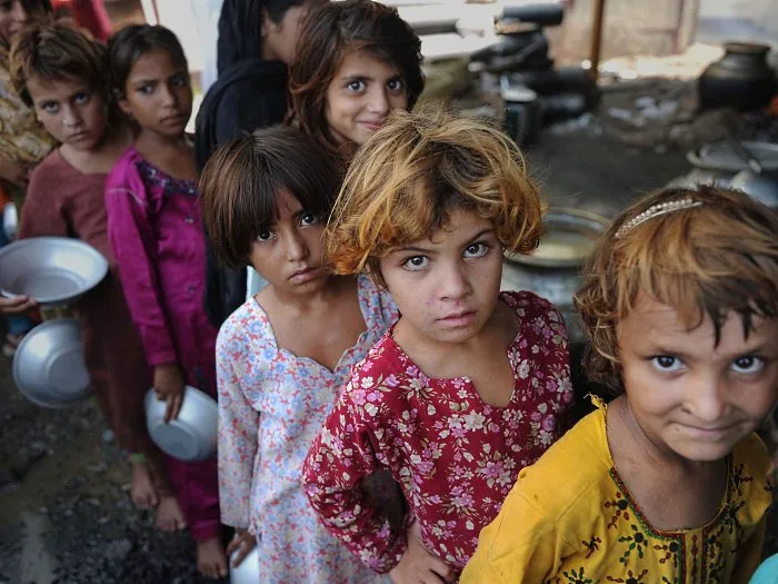 Crianças afetadas pelas enchentes no Paquistão fazem fila para distribuição de comida por ONG