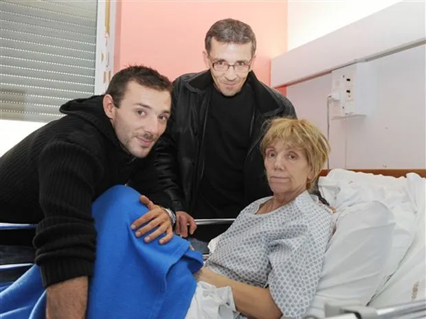  Lydia Paillard posa ao lado de dois de seus filhos na cama do hospital