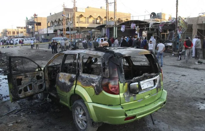  Moradores de Bagdá observam local de atentado ocorrido nesta terça-feira (2); ministro diz que ao menos 64 morreram