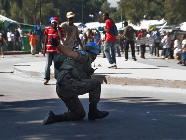  Um dos soldados da missão de paz brasileira cai de um caminhão em frente a manifestantes durante protesto em Porto Príncipe