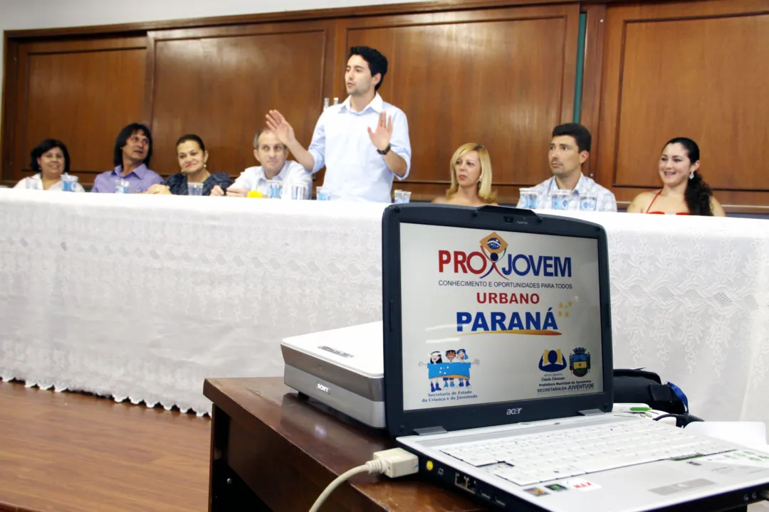 Mesa da solenidade de formatura do Projovem em Apucarana: qualificação profissional e formação para participação cidad