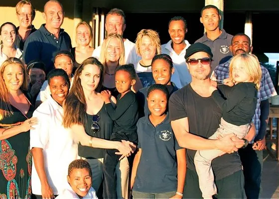  Angelina Jolie e Brad Pitt com as filhas Zahara e Shiloh (respectivamente) com os donos e equipe do santuário Naankuse, na Namíbia, onde a família passou o Nata