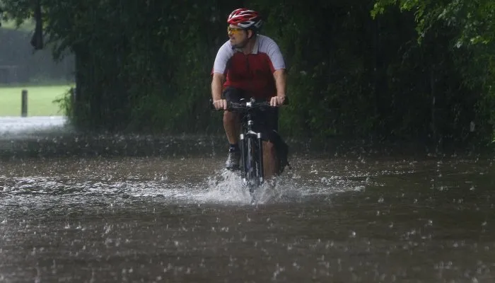  Ciclista passa por inundação na cidade de Brisbane, a terceira maior da Austrália, nesta terça-feira (11)