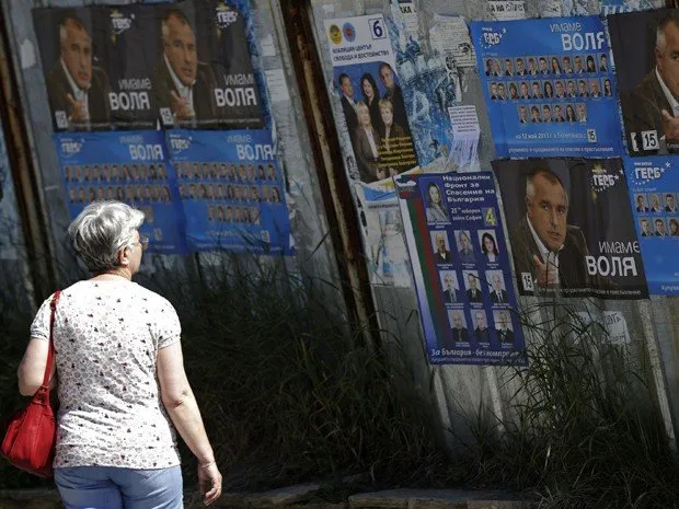  Mulher olha para cartazes eleitorais de Boiko Borisov, líder do partido GERB de centro-direita na Bulgária, em um subúrbio de Sofia no sábado