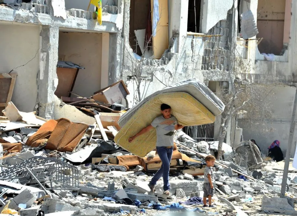 Palestinos procuram casas destruídas por ataques israelenses em escombros no norte da Faixa de Gaza