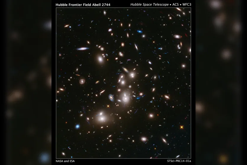   Esta imagem, capturada pelo telescópio Hubble, do aglomerado de galáxias Abell 2744 (em primeiro plano) é o mais profundo de todos os tempos de qualquer aglomerado de galáxias. Ele mostra algumas das galáxias mais fracas e mais jovens já detectado no espaço 