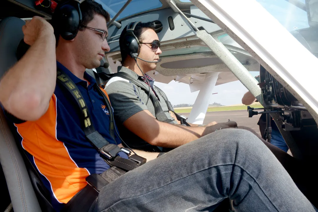 Instrutor Felipe Zanolli e representante comercial Aílton Orides Nascimento se preparam para voo - 