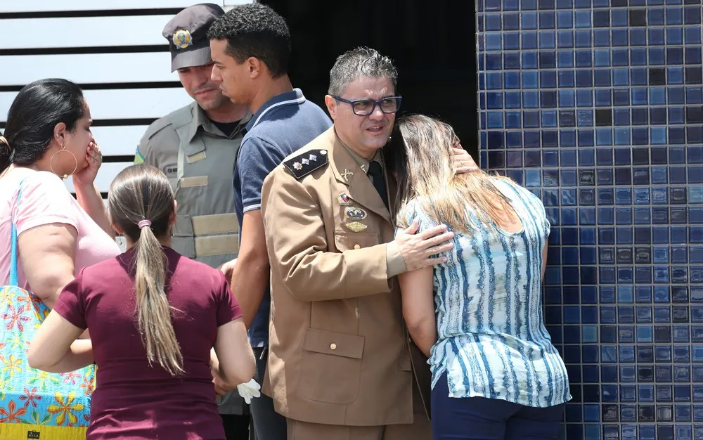 Mulher é consolada na frente do Colégio Goyases, em Goiânia, onde aluno abriu fogo contra colegas em sala de aula (Foto: Cristiano Borges/O Popular/Estadão Conteúdo)