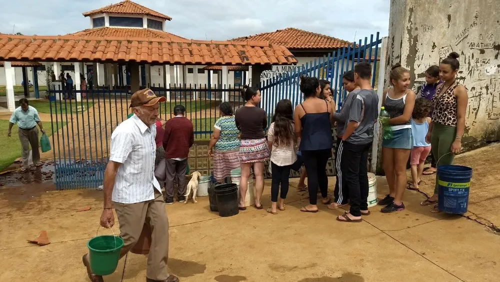 Moradores de Tamarana fazem fila para pegar água em escola, na manhã deste domingo (5) (Foto: Alberto D'Angele/RPC
