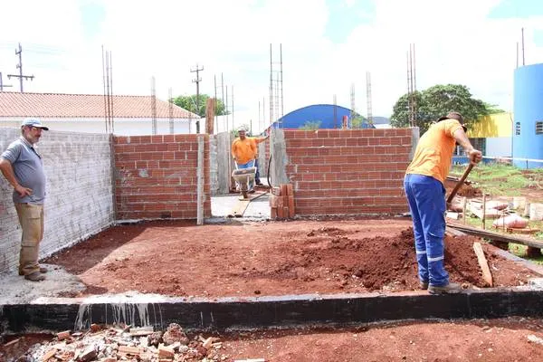 Operário preparando base para pisoulo em construção no Jardim Flamingos
