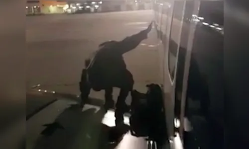 Passageiro impaciente para descer abre porta de emergência e sobe em asa de avião