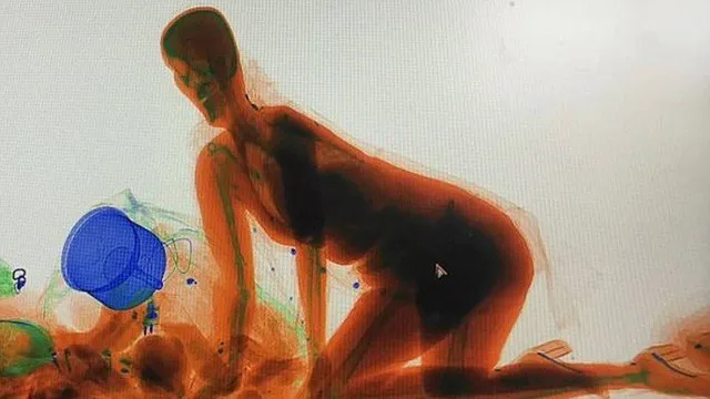Mulher se ajoelha em esteira de raio X para acompanhar de perto a passagem da sua bolsa por checagem de segurança Foto: Reprodução/YouTube(Shanghaiist)